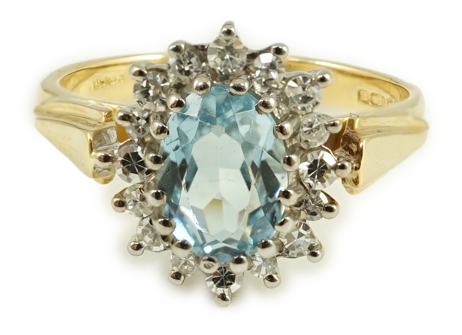 A modern 18ct gold aquamarine and diamond set oval cluster ring, size K/L, gross weight 3.8 grams.